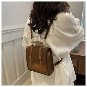 Detailed view of the brown vintage crossbody bag with matte texture and buckle straps