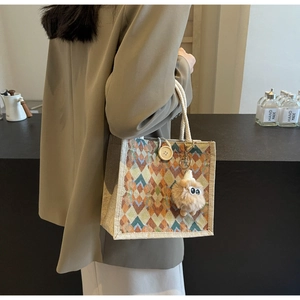 Detail of woven linen tote with geometric rhombus pattern, rope handle and sheep charm