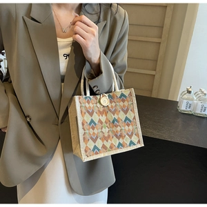 Detail of colorful geometric woven handbag with large button closure and rope handle