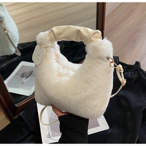 Detail of white faux fur crossbody bag with pleated handle and gold zipper hardware