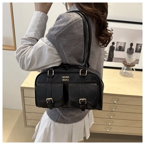 Detail of black vintage PU shoulder bag with dual front pockets and gold hardware
