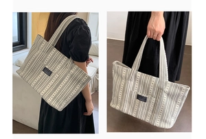 Detail shot of the large striped canvas tote bag with fashion label for daily commuting