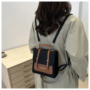 Model wearing a retro black canvas and brown leather backpack for school or daily use