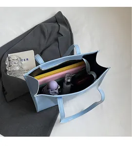 Vue intérieure du sac cabas bleu clair montrant la grande capacité pour ordinateur et effets
