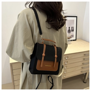 Retro color-block canvas and leather backpack worn with a stylish beige trench coat