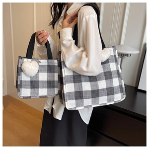 Detail of black and white checkered canvas tote bags with heart plush charm accessories