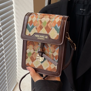 Retro geometric woven crossbody bag with brown leather trim shown in hand for women
