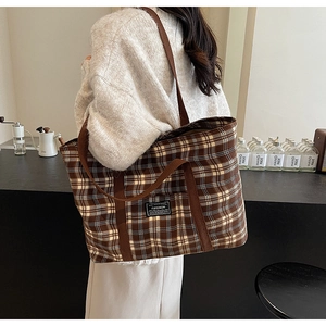 Détail du grand sac cabas à carreaux montrant l'étiquette mode et les anses marron
