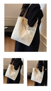 Detail shot of white canvas tote bag featuring double front pockets and sturdy shoulder straps