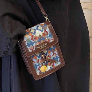 Retro multi-color geometric woven crossbody bag with brown leather trim and gold pendant