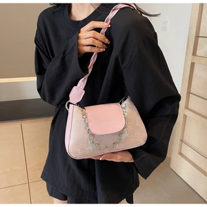 Pink baguette bag with floral embroidery, silver clover chain, and wide woven strap