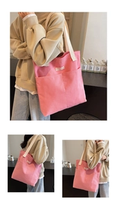 Detail view of pink canvas tote bag with thick cream shoulder straps and front pockets