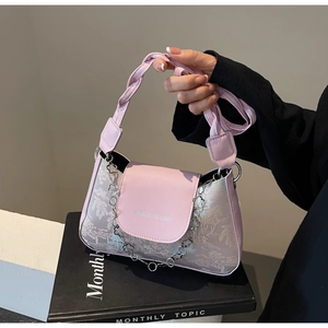 Detail of pink baguette bag featuring floral silver chain and traditional jacquard pattern