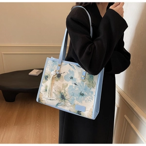 Sac fourre-tout style français avec motif floral bleu et élégant pendentif à franges