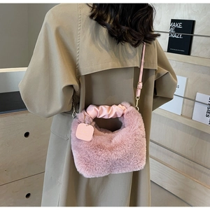 Detail of pink faux fur crossbody bag with pleated leather handle and detachable strap