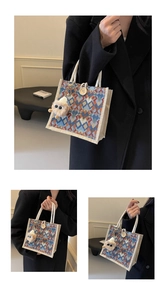 Detail of knitted tote bag with orange geometric patterns, wooden toggle, and plush charm
