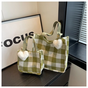 Detailed view of green checkerboard tote bags with heart charm and canvas texture