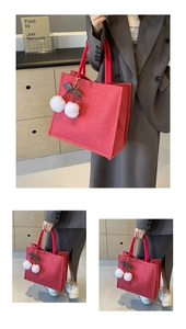 Detail of red linen tote bag featuring cute plush cherry charms and thick canvas material