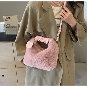 Detail of pink faux fur handbag showing pleated handle and adjustable crossbody strap