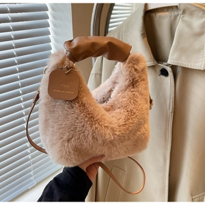 Macro detail of plush faux fur texture and ruched PU leather handle on a stylish handbag