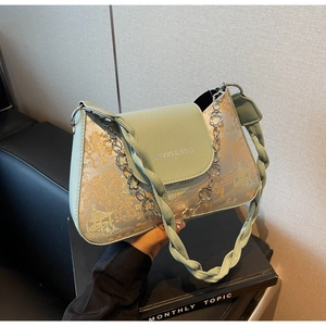 Detail of mint green baguette bag featuring golden landscape brocade and floral chain