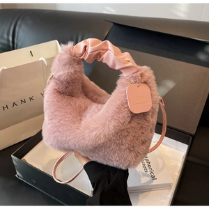 Detail of light pink faux fur handbag with scrunched handle in an elegant gift box