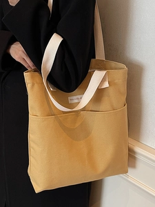 Minimalist ginger yellow canvas tote bag with dual front pockets and cream straps