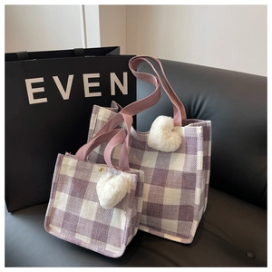 Detail of purple plaid tote bags in large and small sizes with plush heart pendants