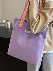 Purple canvas tote bag with pink handles and large front pockets for daily commute