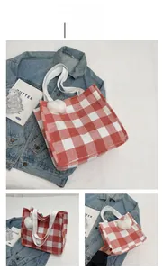 Detail of red gingham tote bags in two sizes with white pom-pom and canvas handles