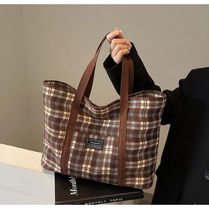 Détail d'un grand sac cabas en toile à carreaux avec étiquette mode et anses en tissu