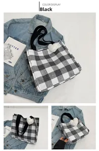 Detail of black and white checkered tote bag with plush heart charm on denim jacket