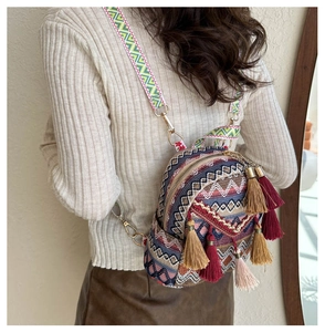 Close-up of ethnic woven backpack featuring colorful tassels and geometric wave patterns