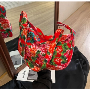 Detail of red floral tote bag showing traditional peony patterns and metal buckle