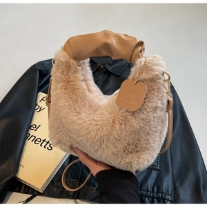 Close-up of plush apricot tote bag with ruched leather handle and gold hardware detail