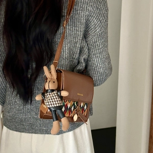 Brown vintage crossbody bag with diamond pattern detail and cute rabbit plush charm