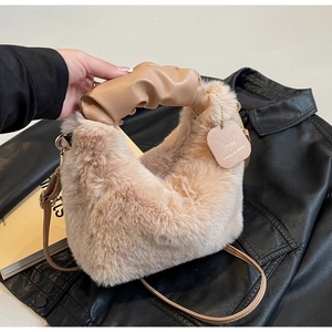 Detail of plush faux fox fur handbag with ruched leather handle and gold hardware