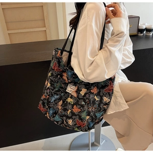 Close-up of vintage black tote bag with colorful butterfly jacquard and woven label detail