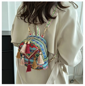 Close-up detail of ethnic style backpack with colorful tassels and woven texture strap