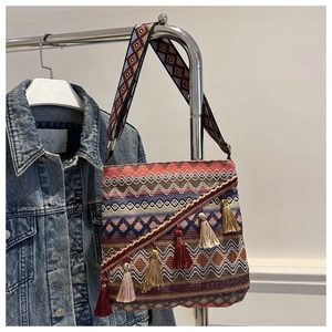 Détail d'un sac bohème tissé coloré avec motifs ethniques et pompons multicolores