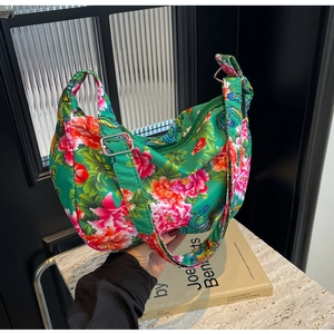 Close-up of green floral tote with traditional peony patterns and silver buckle detail