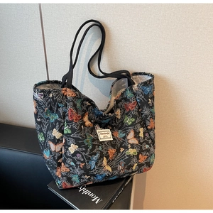 Detail of colorful butterfly jacquard tote bag showing woven texture and black straps