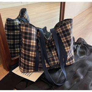 Détail du sac cabas en toile à carreaux avec étiquette mode et poignées bleues