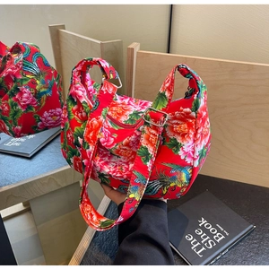 Detail of red floral tote bag showing traditional peony patterns and metal hardware