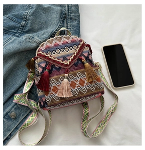 Detail of bohemian mini backpack featuring colorful geometric patterns and fringe tassels