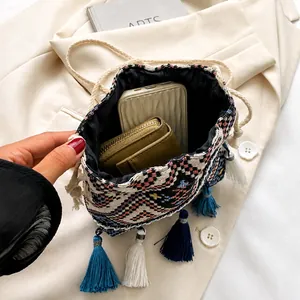 Top-down view of a spacious ethnic bucket bag interior with colorful tassels and black lining