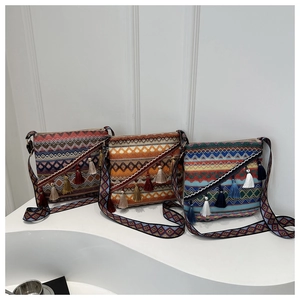 Détail de trois sacs à bandoulière tissés bohèmes avec pompons et larges bretelles à motifs