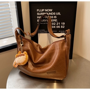Brown vintage faux leather tote bag with fashion label and cute plush bear charm