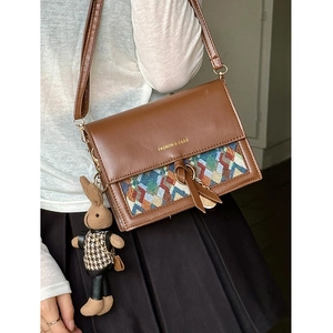 Brown leather crossbody bag with colorful woven pattern and cute rabbit charm