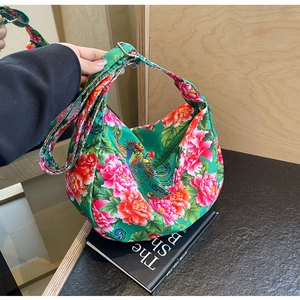 Detail of green floral crossbody bag featuring traditional peony and phoenix embroidery